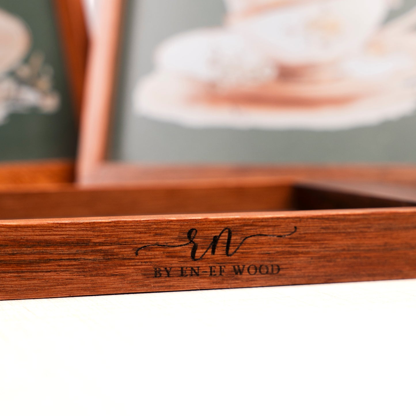 Wooden picture frame with 'EN-EE WOOD' engraving on a blurred background