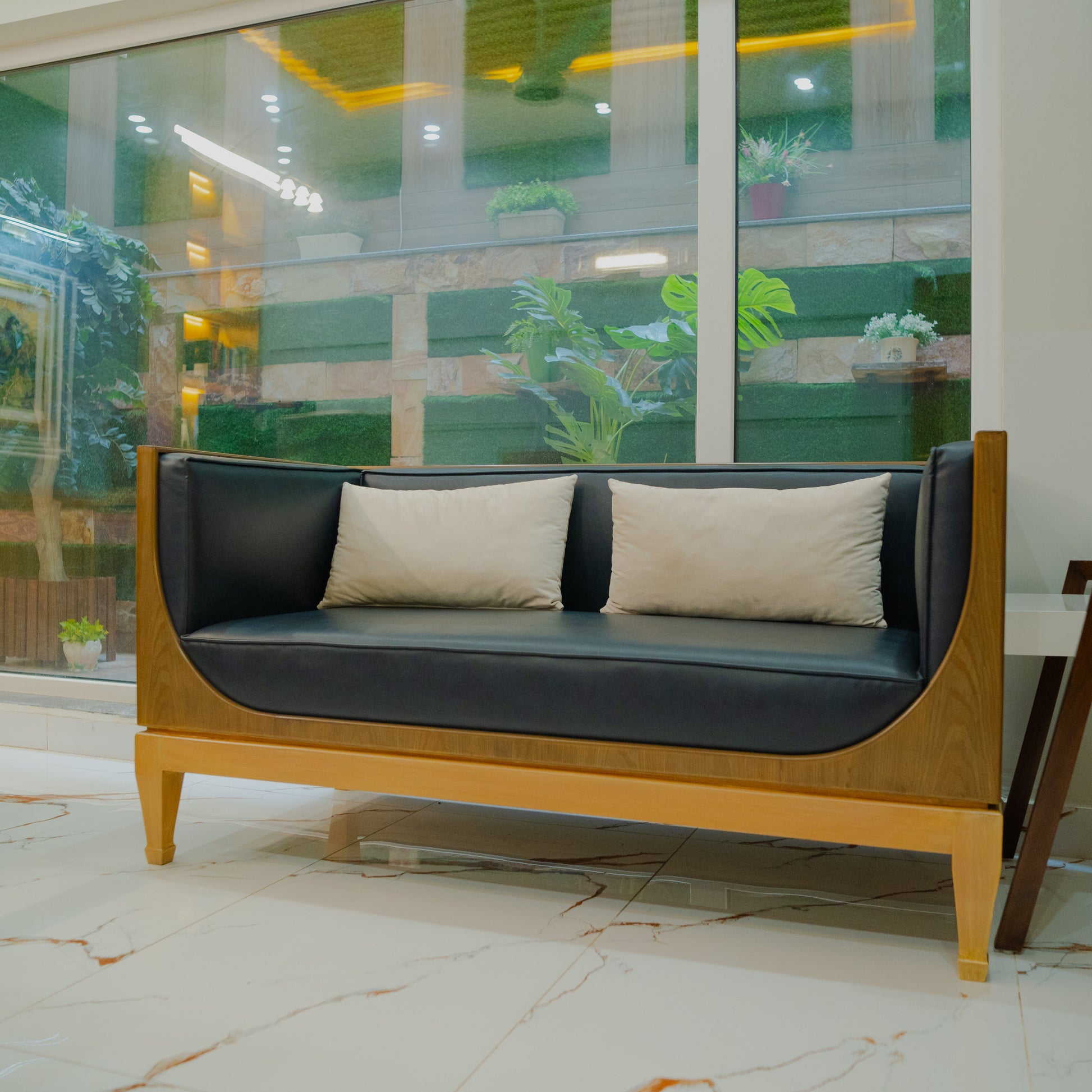 Modern black and brown sofa in a room with large windows.