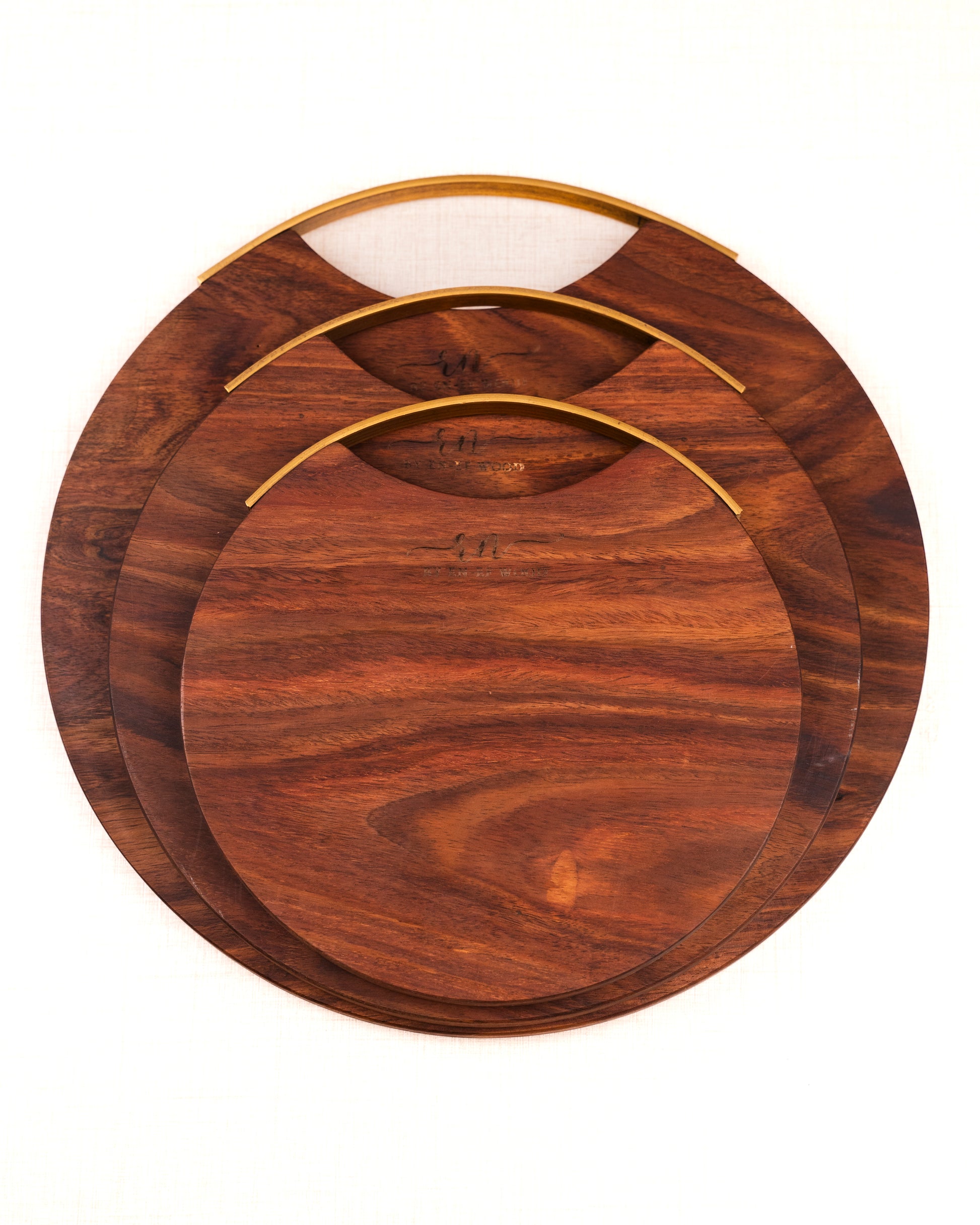 Set of three wooden cutting boards with gold edges on a white background