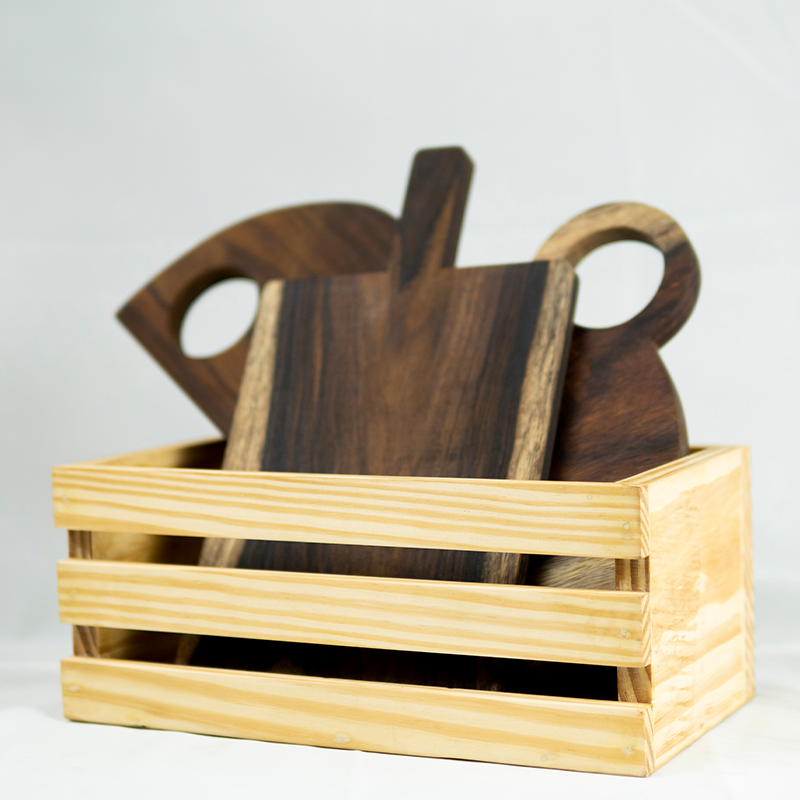 Set of wooden cutting boards in a rectangular wooden holder on a light gray background