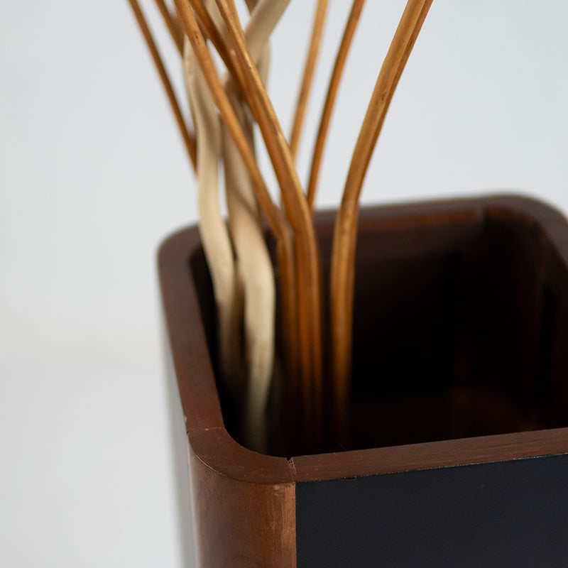 Wooden vase with dried plants on a white background